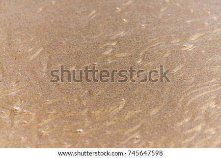 close up of the sea water affecting the sand on the beach, sea waves calmly flowing sand, relaxing view, summer time
