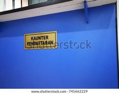 Kaunter Pendaftaran (registration counter) signage closeup in a clinic.
