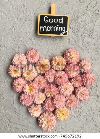flower morning. love morning. pink chrysanthemums heart on grey cement background with chalkboard good morning 
