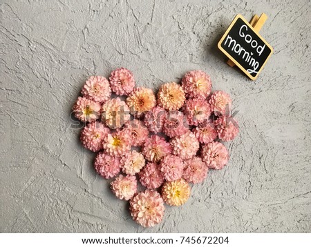 flower morning. love morning. pink chrysanthemums heart on grey cement background with chalkboard good morning 
