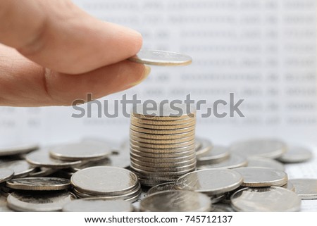 Money, Financial, Business Growth concept, Man's hand put a coin to stack of coins with bank passbook as background.