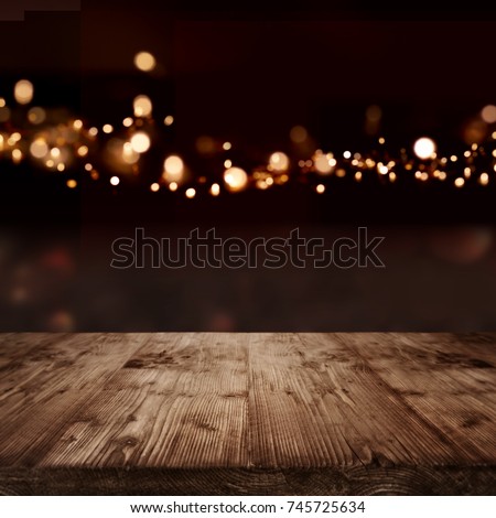 Festive background with golden bokeh effects and empty wooden table for a christmas decoration