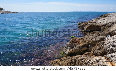 Photo of small port of Afrodite near Marina Zeas with picturesque small chapel and beautiful spring flowers, Peiraeus, Attica, Greece                               