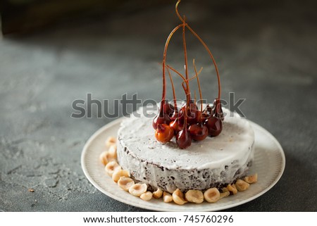 Chocolate cake with caramelized hazelnuts and icing topping on black slate background from above