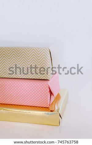 Close-up of three stacked present boxes with modern minimalist packaging.