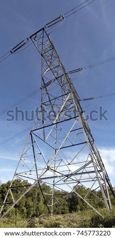 Looking up at a power transmission tower.