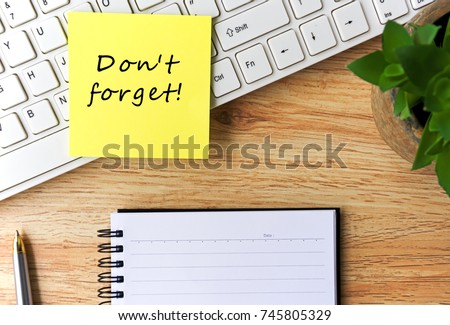 Open notepad and sticky notes with word "don't forget" on top of wooden table Royalty-Free Stock Photo #745805329