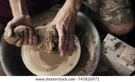 Serious woman working at pottery wheel in studio, prepare clay to make plate to restaurant