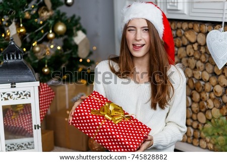 A happy cheerful girl with a gift celebrating new year 