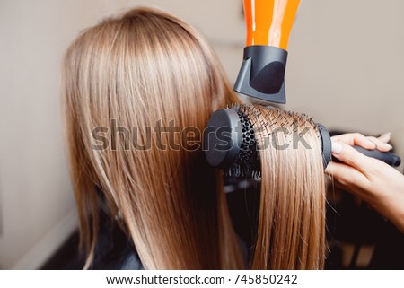 Close-up of hair dryer, concept barber salon, female stylist. Royalty-Free Stock Photo #745850242