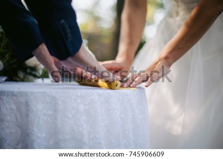 hands of the newlyweds, close-up, candle