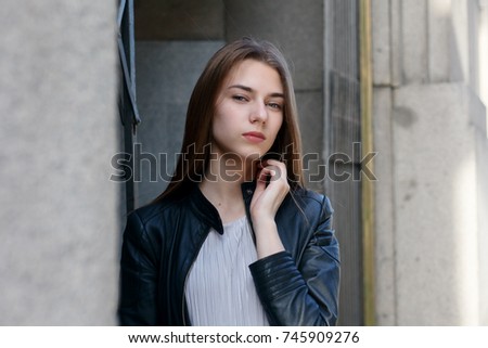 people, emotions, natural, beauty and lifestyle concept - Young beautiful woman in dress and leather jacket standing at roof near fence