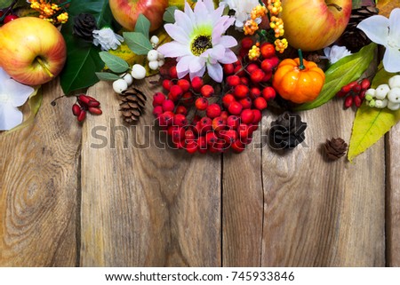 Thanksgiving or fall decoration with pumpkin, apples, autumn leaves and rowan berries on the rustic wooden background, copy space 