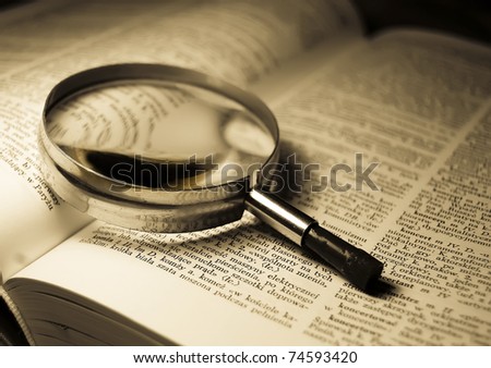 View through loupe at book Royalty-Free Stock Photo #74593420