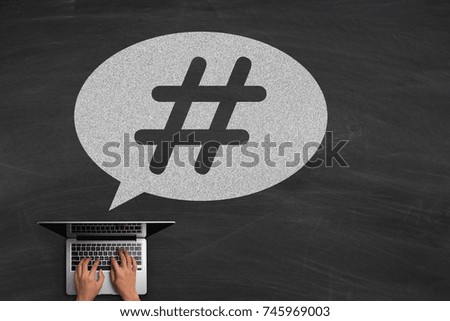 Hashtag post viral web network media tag business concept with hands typing laptop on the blackboard background.