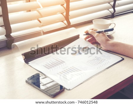 Businesswomen review graphs and charts report with pen on right hand. Financial advisory. Sales review. Financial abstract concepts