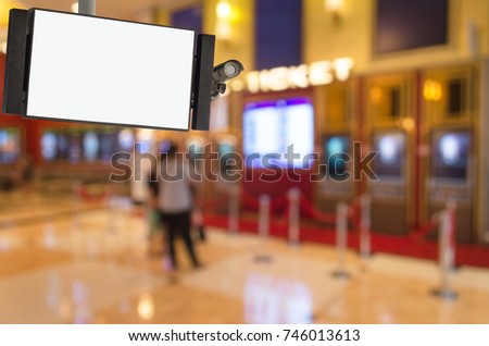 CCTV and LCD TV with white blank screen or billboard with blurred image of people buy cinema tickets from automatic ticket machine at movie theater, advertising, commercial and marketing concept
