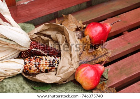 Autumn background with corn, pears and yellow leaves
