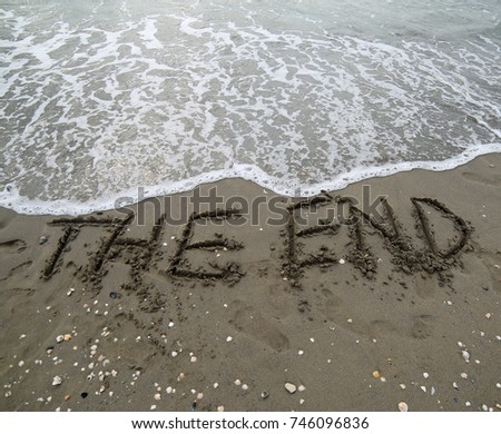 THE END text written on the sand and the wave that is deleting the word can be used for the purpose of corporate presentations