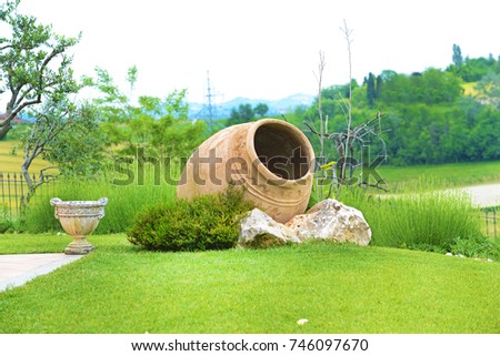 Landscape with large terracotta amphorae lying in the garden. Royalty-Free Stock Photo #746097670