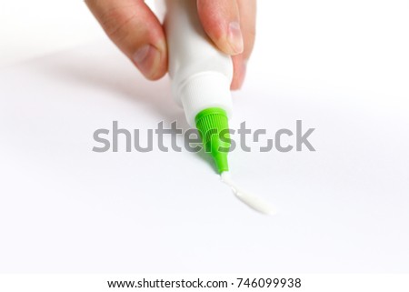 Hand holding a bottle of glue. Deals PVA glue on paper. Isolated on white background.