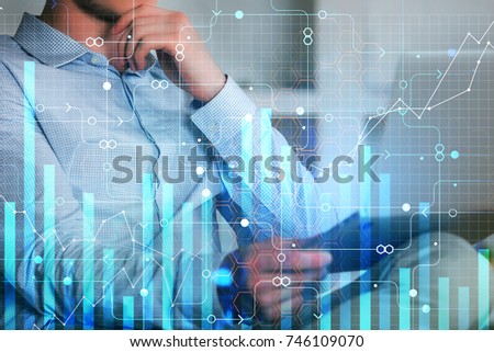 Businessman using tablet at blurry workplace with digital business chart. Report and finance concept. Double exposure 