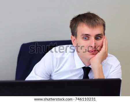 Business man looks on computer and shocked / surprised. 