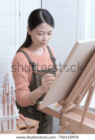 Young female artist painting picture