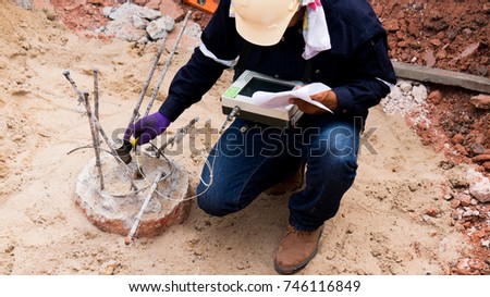 Seismic Test (Low Strain Pile Integrity Test), Engineer using the PIT Hand-Held Hammer, the PIT Accelerometer and the Pile IntegrityTester to detect Neck(Bulge) and Void in the piles Royalty-Free Stock Photo #746116849