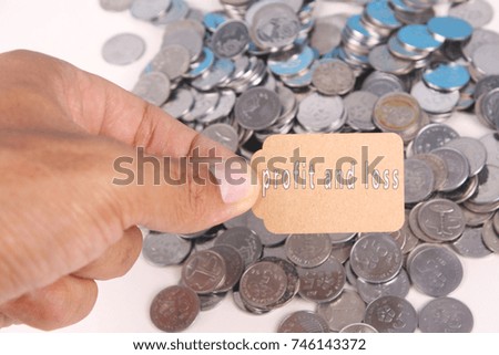 Photo for profit and loss text in small tag with coins on table
