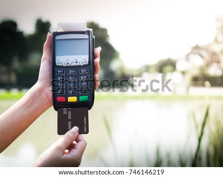 credit cards swipe through terminal on nature background