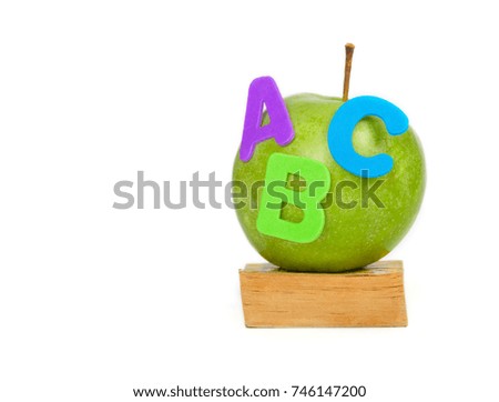 Green apple and A,B,C letters on a small book. Closeup 