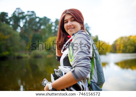 Photo of happy woman with backpack and bicycle helmet