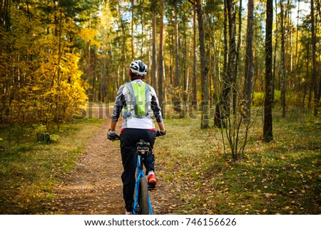 Image from back of girl in helmet on bicycle