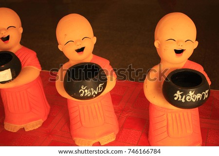 decorative figurines fun of Buddhist monks with pots for donations which made the inscription: for luck, for happiness, for prosperity, for health