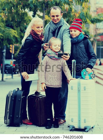 Traveling russian spouses with children shooting mutual portrait on cell phone 