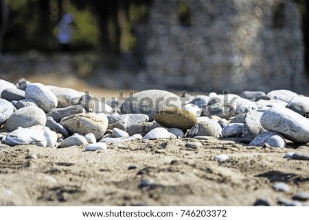 At the beach near the water are marine pebbles. Reference picture