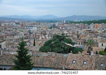 Evening panorama of the Spanish city of Girona - modern and old houses with the mountains in the background