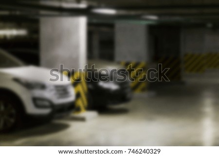 Almost empty underground  parking garage. Industrial loft concrete dark  interior background. Blurred .