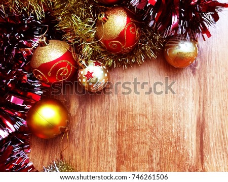 Red and gold Christmas decorations and shiny tinsel on the background of natural wooden floor with a copy space. New year, Christmas background