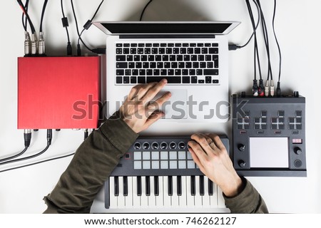 Producing and mixing modern style beats music, beat making and arranging audio content with software controllers and digital effects processors. Recording electronic music track in home studio Royalty-Free Stock Photo #746262127