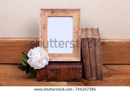 Vintage wood frame with old books on table. Mock up for your photo or text