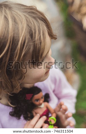 Young girl holding a doll.