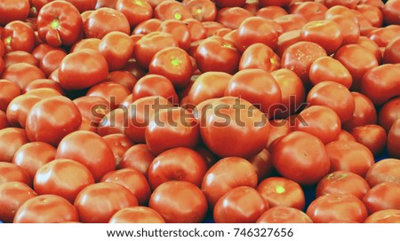 ripe red tomatoes are on the counter of the vegetable store