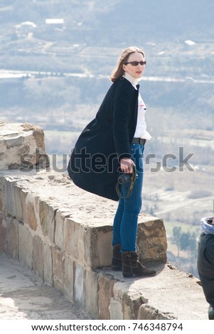 Young woman standing on the wall of Jvari Monastery, a sixth century Georgian Orthodox monastery near Mtskheta, eastern Georgia