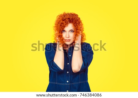 Hear no evil concept. Portrait of young attractive redhead woman curly hair retro style covering with hands her ears eyes opened isolated on yellow wall background