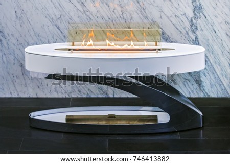 small portable fashionable fireplace, white modern fireplace on a background of marble wall