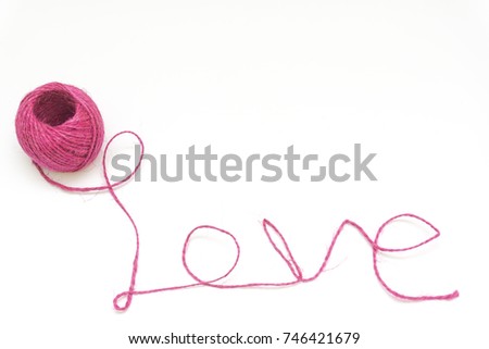 Word love written with pink wool thread on white background