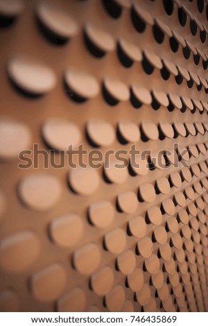 Perforated sheet metal wall in copper color.