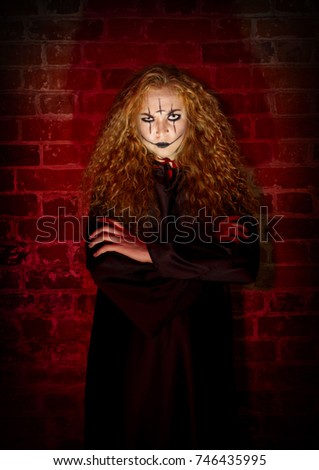 Scary witch at brick wall background